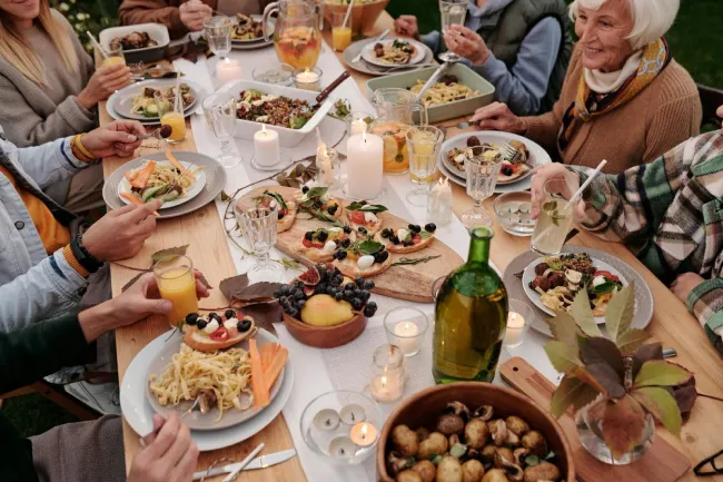 Harvest Time and Preparing for the Future in California - Art Garden Design https://artgardendesign.net/wp-content/uploads/01-sept.webp 1 view from above of people sitting around a dining table covered with candles and food