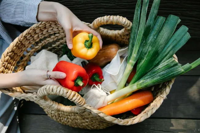 Harvest Time and Preparing for the Future in California - Art Garden Design https://artgardendesign.net/wp-content/uploads/01-sept.webp 2 female hands placing a red and yellow pepper into a basket filled with other vegetables.