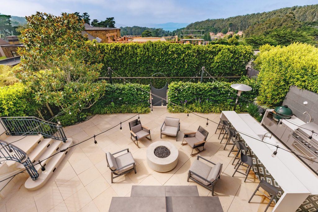 Overview of a San Francisco backyard terrace with fire pit, lounge seating and outdoor kitchen